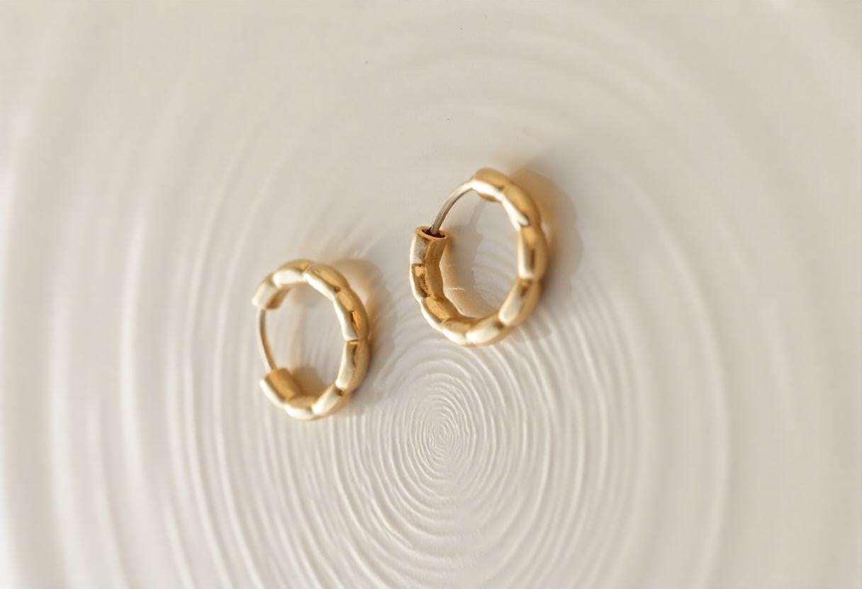 freepik__two-golden-earrings-on-a-rough-surface-with-water-__48700